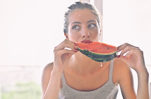Frau beißt in Wassermelone