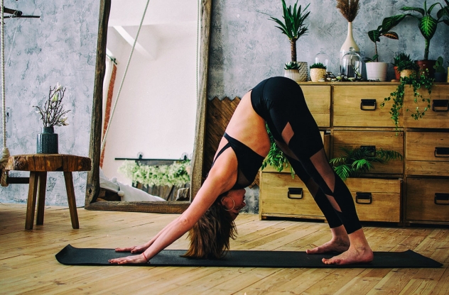Frau in Yoga Pose Herabschauender Hund