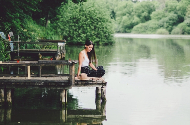 Frau auf Steg am Wasser