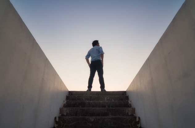 Man steht am Ende einer Treppe im Sonnenuntergang