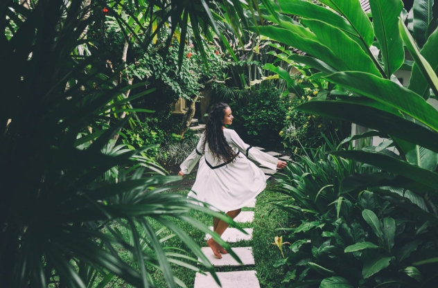 Frau tanzt im tropischen Garten