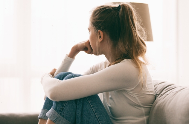 Frau sitzt gekränkt auf dem Sofa