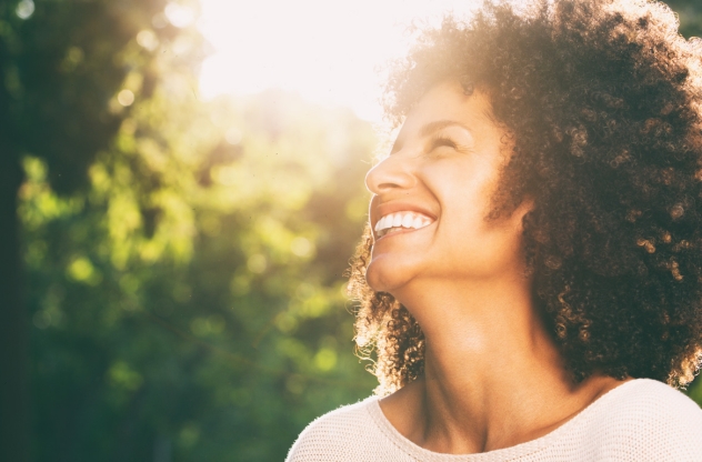 Toxische Positivität toxic positivity lachende Frau in Sonnenschein