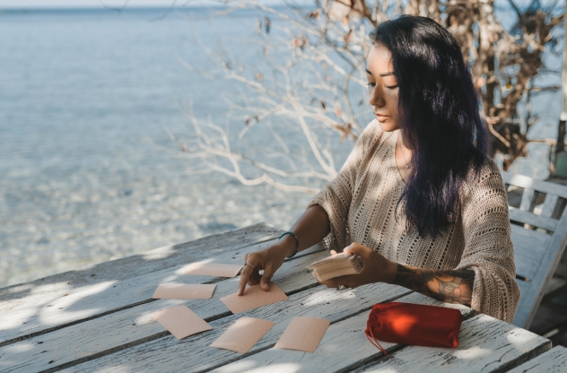 Frau legt Tarot-Karten am Meer