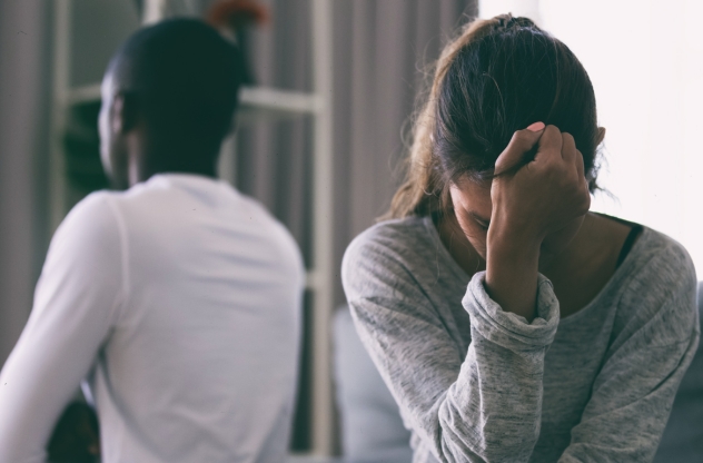 Mann und Frau sitzen mit dem Rücken zueinander und haben ein Missverständnis