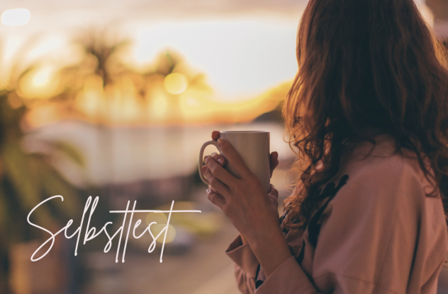 Eine Frau hält eine Tasse in der Hand und schaut bei Sonnenuntergang auf das Meer. Auf dem Bild steht das Wort "Selbsttest".