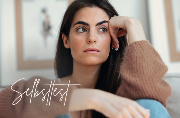 Eine Frau sitzt auf einem Sofa und blickt in Gedanken versunken zur Seite | Overthinking Test