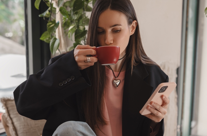 Kaffeetrinkende Frau mit Handy