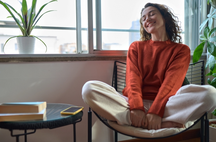 Lächelnde Frau im Schneidersitz