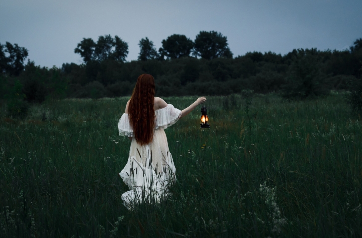 Frau mit Laterne auf einem Feld