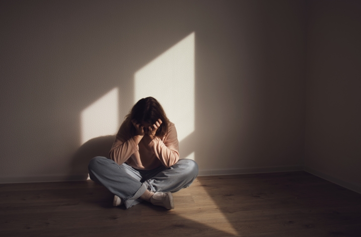 Sitzende Frau mit Kopf auf den Händen gestützt