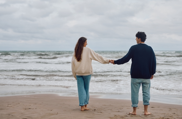 Paar das Händchen hält vor Meerhintergrund