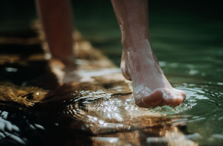 Füße die durch Wasser laufen