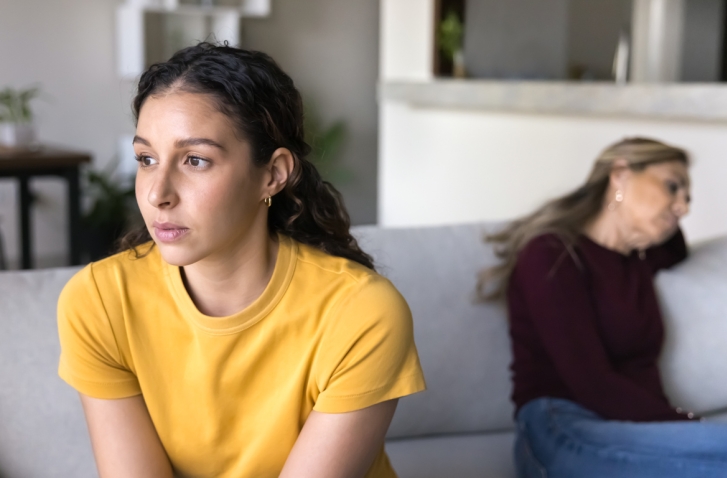 Zwei Frauen die voneinander abgewandt auf eine Sofa sitzen