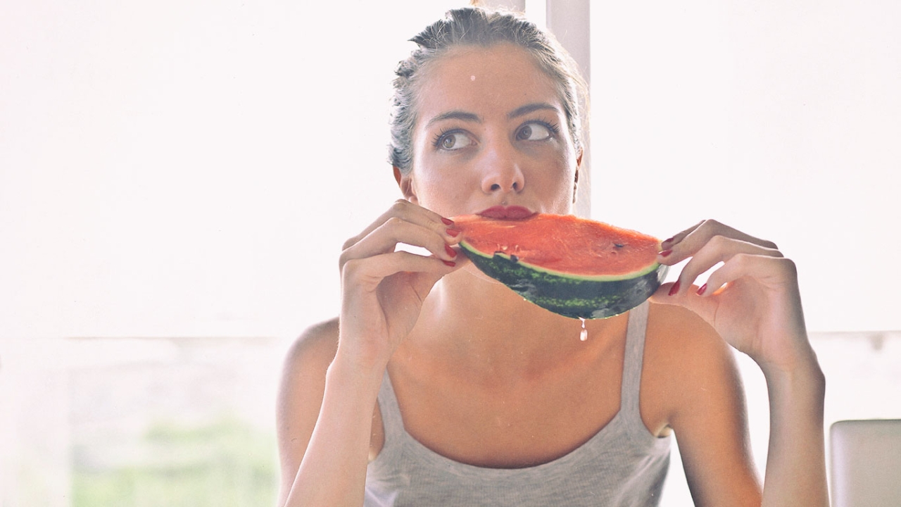 Frau beißt in Wassermelone