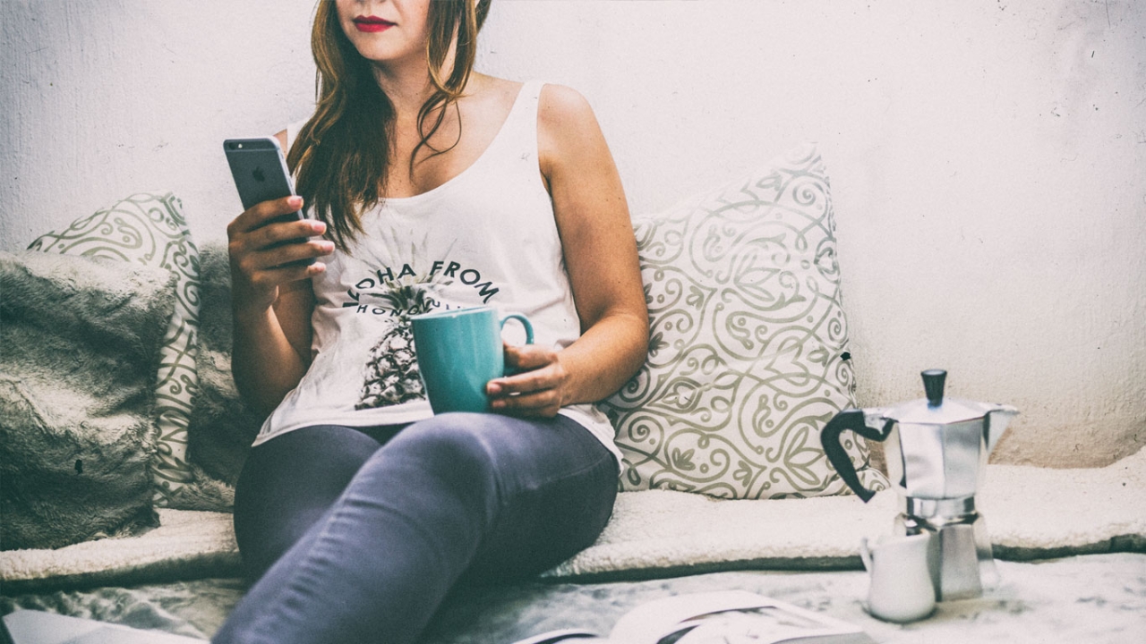 Karima Stockmann: Social Media gleich Meditationszeit Frau schaut auf ihr Smartphone und trinkt Kaffe