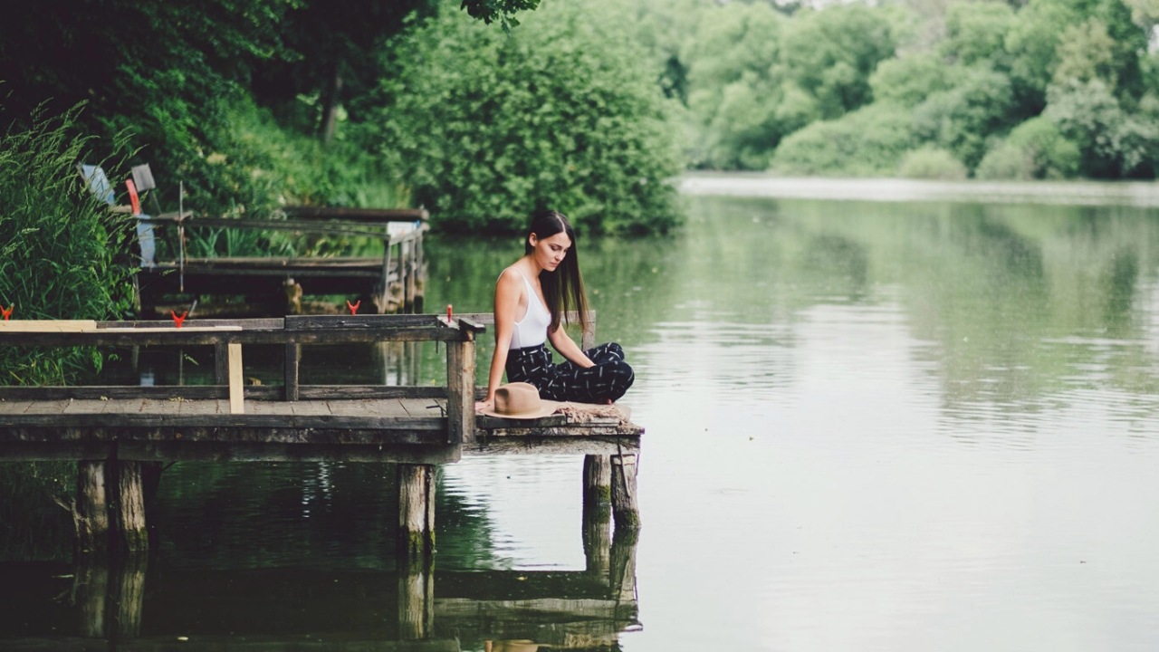 Frau auf Steg am Wasser