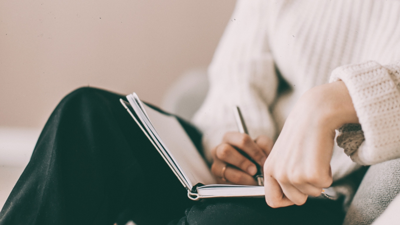 Frau schreibt in einem Tagebuch