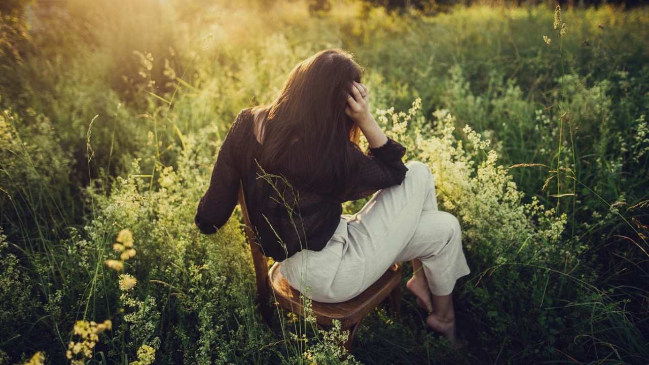 Frau wippt auf Stuhl in Natur Frau wippt auf Stuhl in Natur
