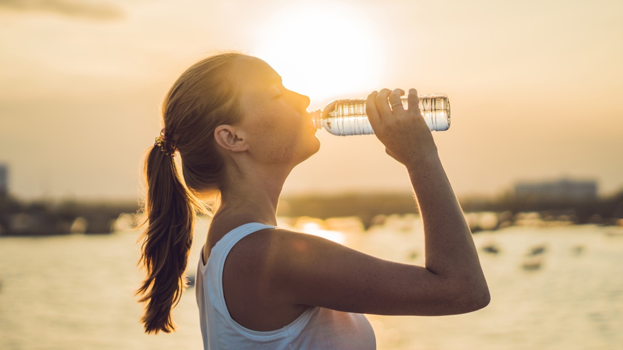 Frau trinkt Wasser, um Stoffwechsel anzuregen