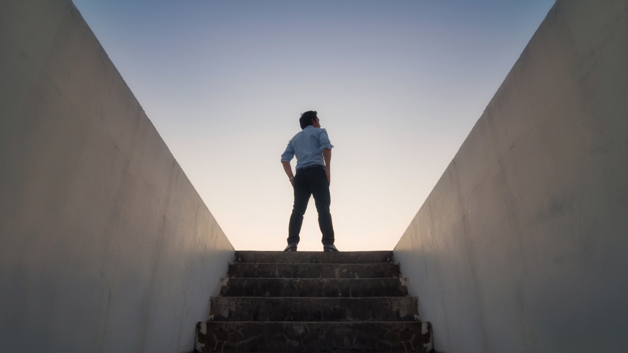 Man steht am Ende einer Treppe im Sonnenuntergang