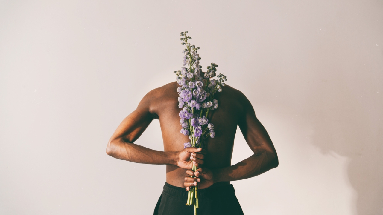 Mann mit Blumen am Rücken