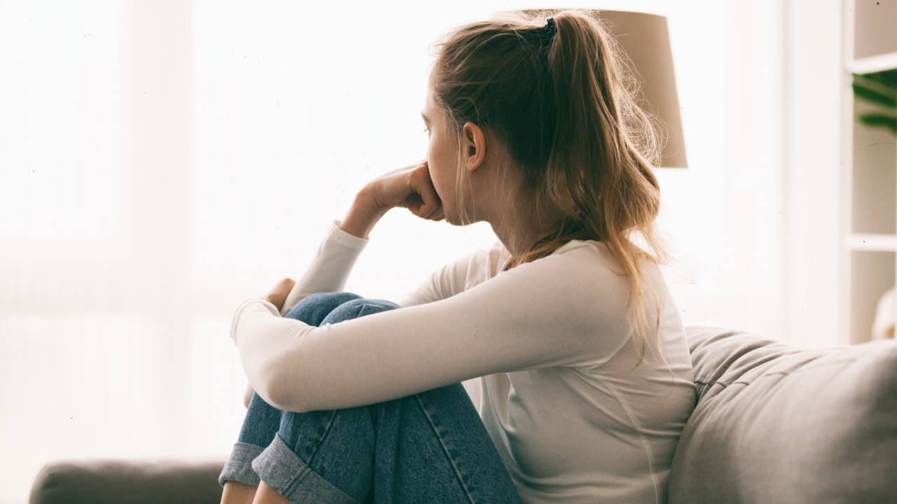 Frau sitzt gekränkt auf dem Sofa