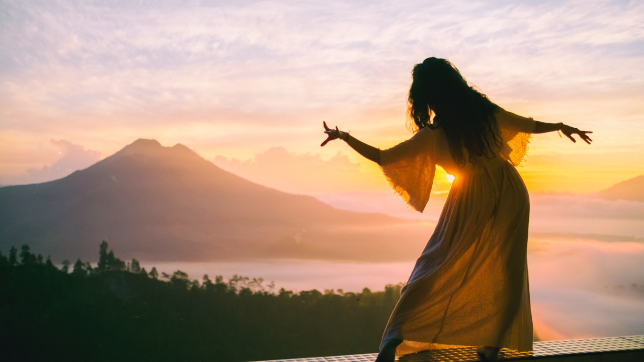 Sakralchakra Frau macht Sakralchakra-Übung bei Sonnenuntergang