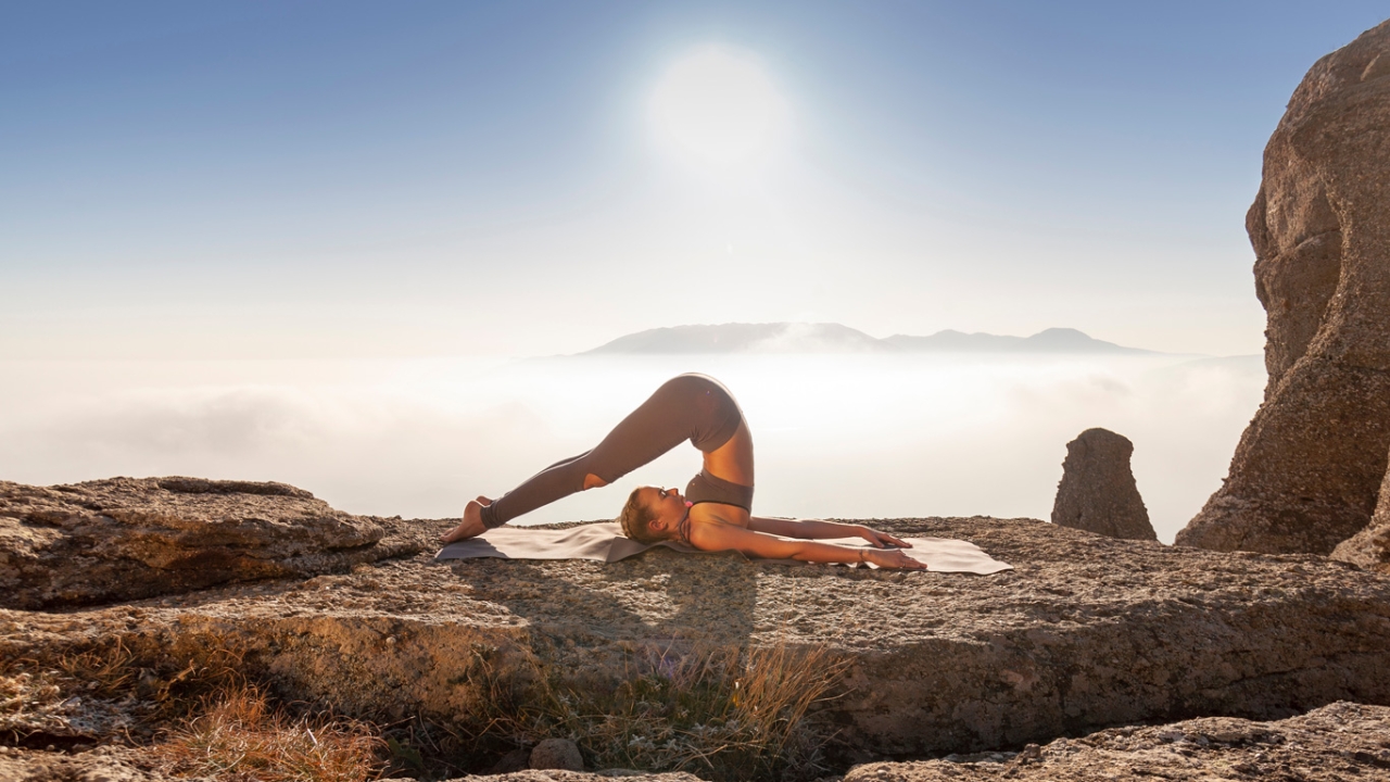 Frau macht Yogaübung Pflug für das Halschakra