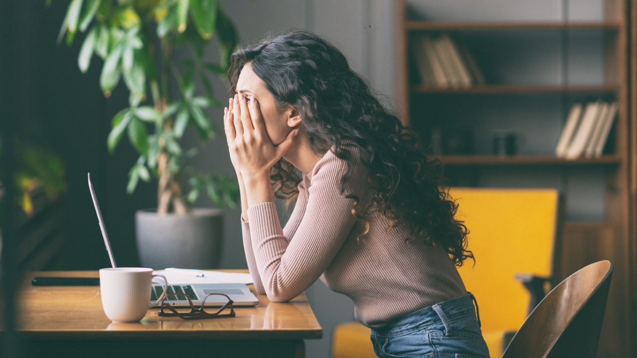 Frau sitzt energielos am Schreibtisch Frau sitzt energielos am Schreibtisch