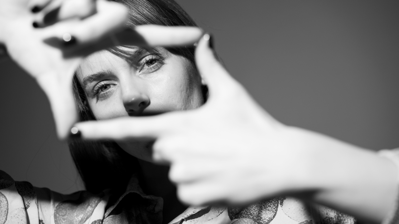 Frau bildet Rahmen mit den Fingern Reframing schwarz-weiss