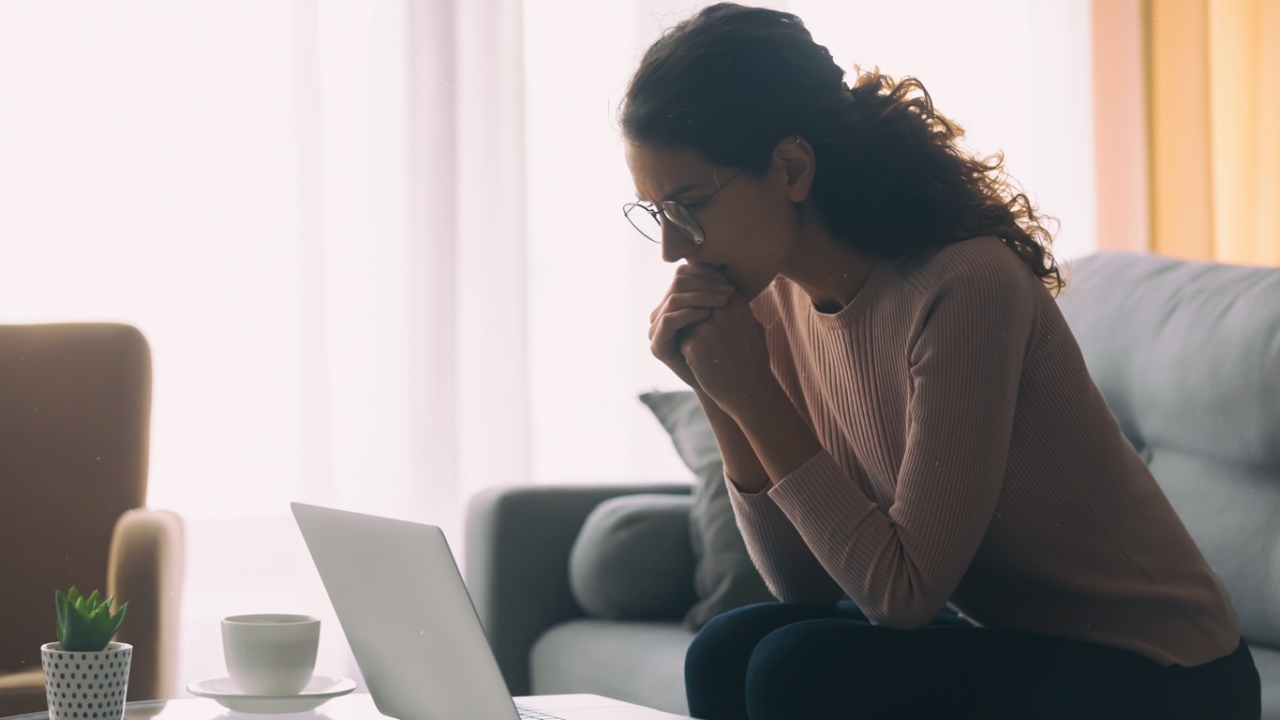 Angst vor neuem Job Frau sitzt zweifelnd vor ihrem Laptop