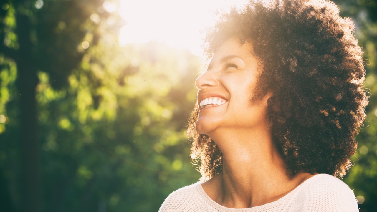 Toxische Positivität toxic positivity lachende Frau in Sonnenschein Toxische Positivität toxic positivity lachende Frau in Sonnenschein