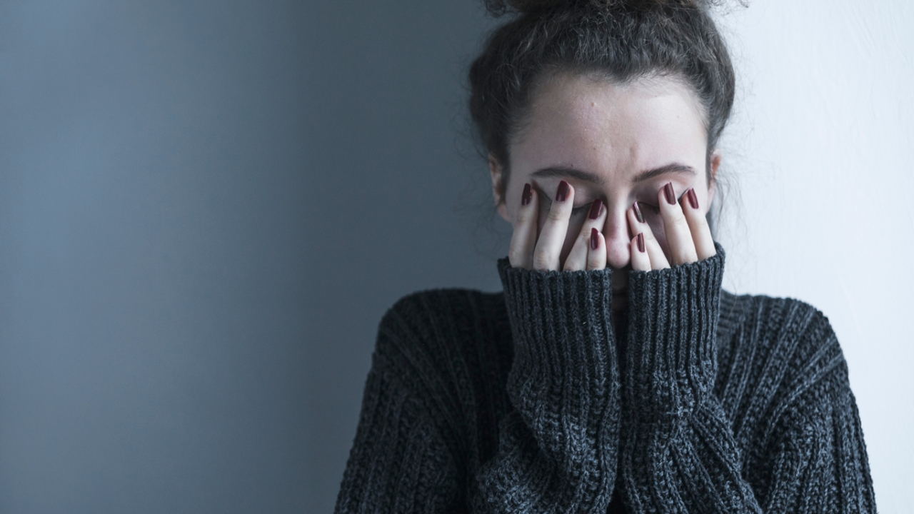 Frau versteckt ihr Gesicht hinter ihren Händen mit Generalisierte Angststörung Frau versteckt ihr Gesicht hinter ihren Händen mit Generalisierte Angststörung