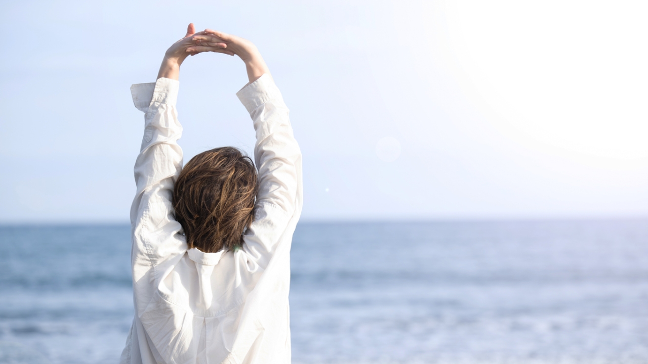 Mittelalte Frau in den Wecheljahren streckt sich am Stand