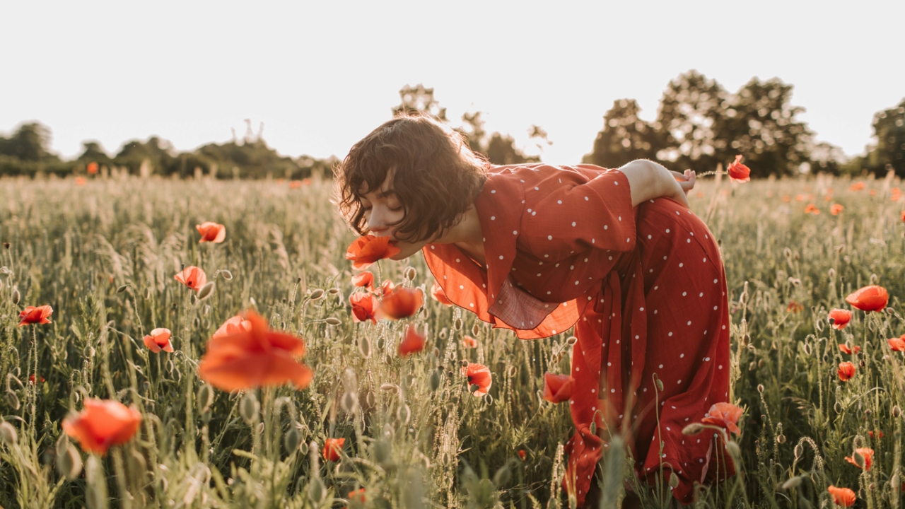 Selbstakzeptanz: Frau im roten Kleid im Mohnfeld
