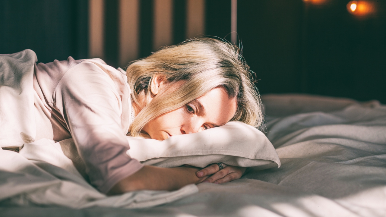 Traurigkeit überwinden: Frau liegt traurig im Bett