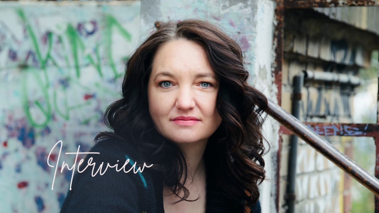 Diane Hielscher sitzt auf Treppe vor Wand mit Graffiti