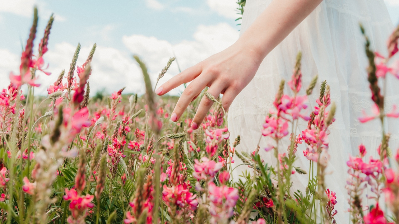 Altlasten loswerden und seelischen Ballast abwerfen: Frau im Blumenfeld