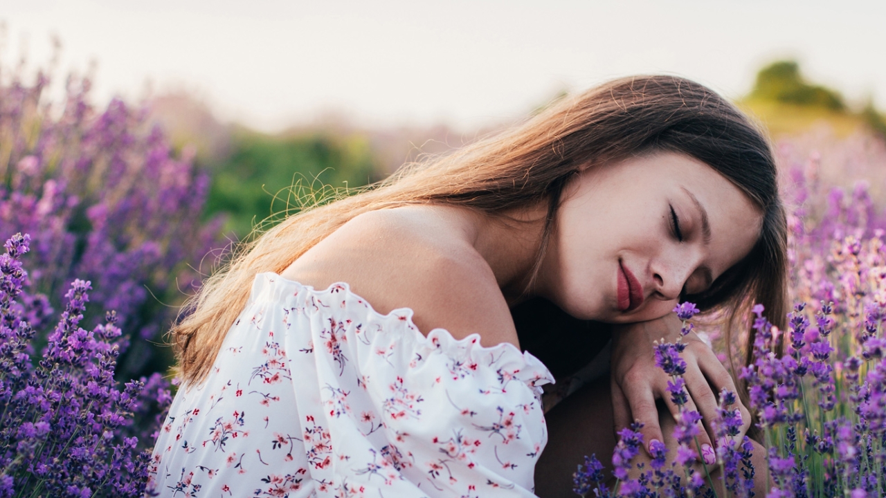 Eine Frau sitzt in einem Lavendelfeld