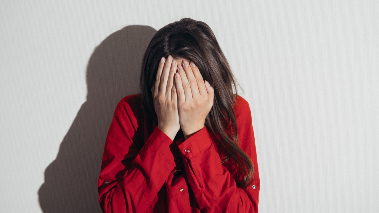 Eine Frau hält sich die Hände übers Gesicht. Emotionale Trigger