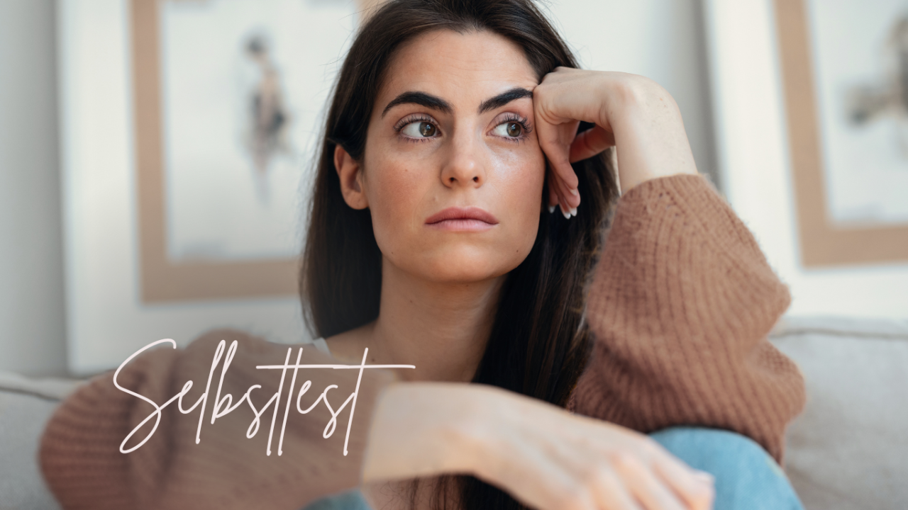 Overthinking in Beziehungen stoppen Eine Frau sitzt auf einem Sofa und blickt in Gedanken versunken zur Seite | Overthinking Test