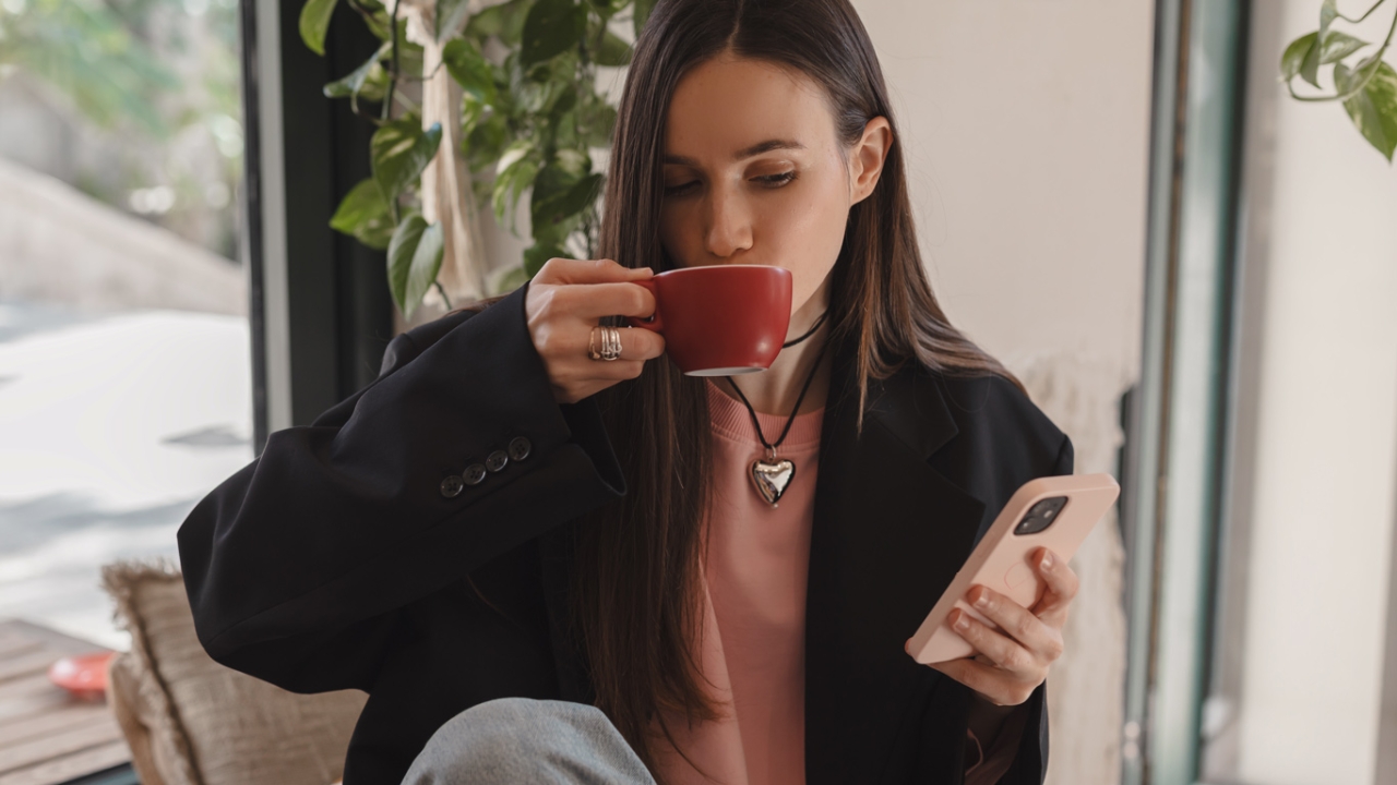 Kaffeetrinkende Frau mit Handy