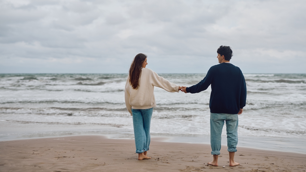 Paar das Händchen hält vor Meerhintergrund