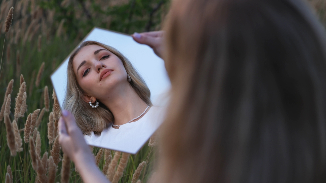 Frau, die in einen Spiegel blickt