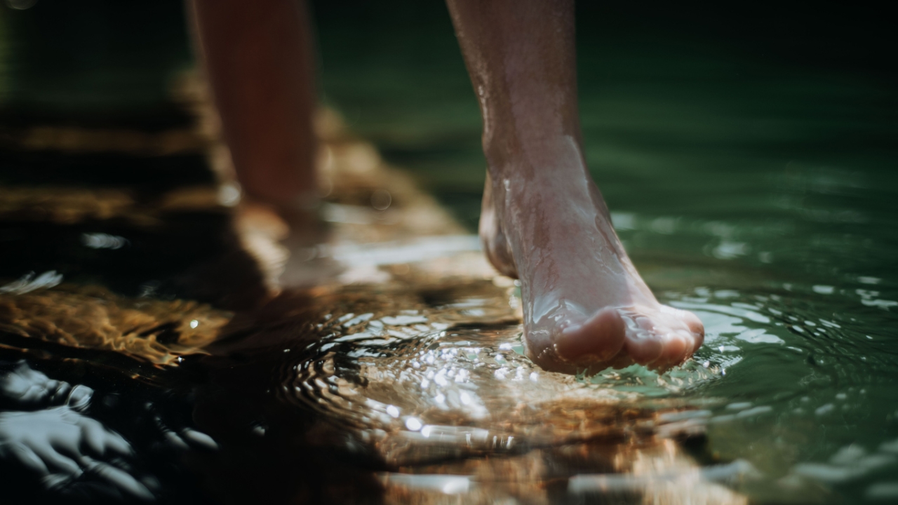 Füße die durch Wasser laufen