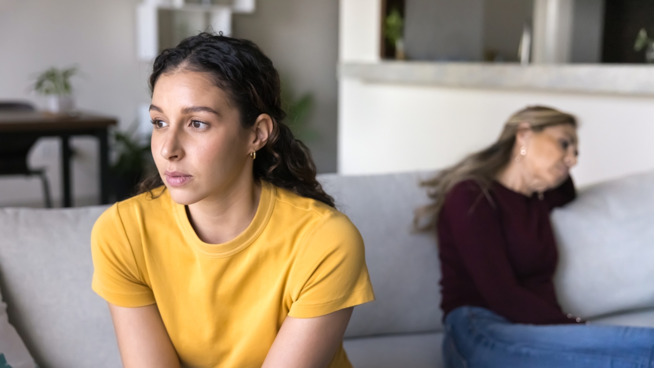 Zwei Frauen die voneinander abgewandt auf eine Sofa sitzen